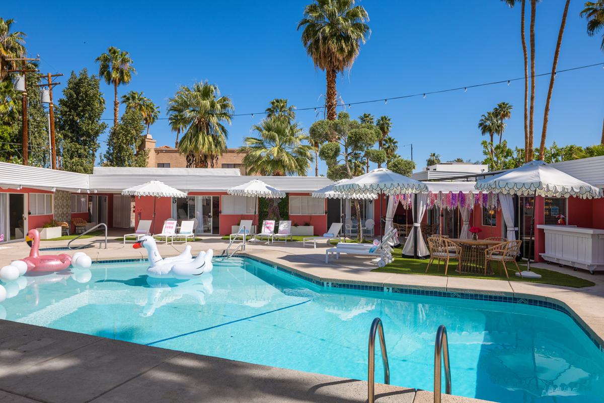 A white swan float in the pool at The Muse Palm Springs on a clear blue sky day