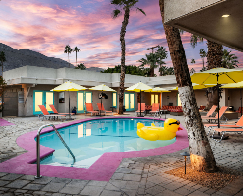 A colorful sunset in the background at El Noa Noa's pool area