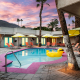 A colorful sunset in the background at El Noa Noa's pool area