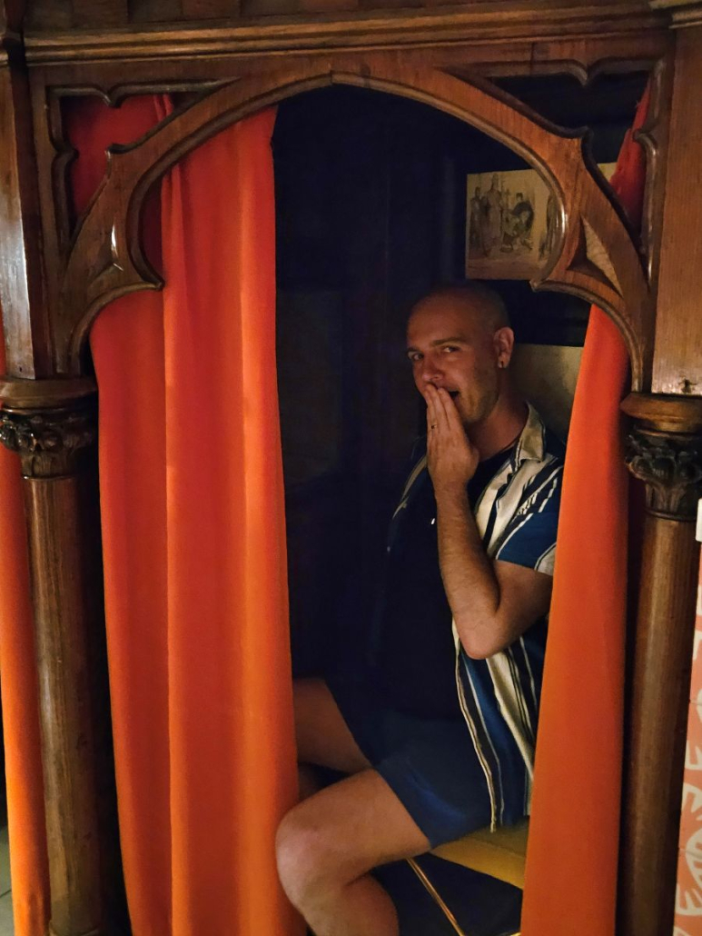 A man sits inside a confessional booth at Counter Reformation