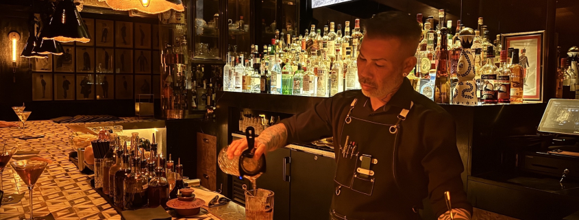 A bartender at Seymour's pours a drink behind the bar