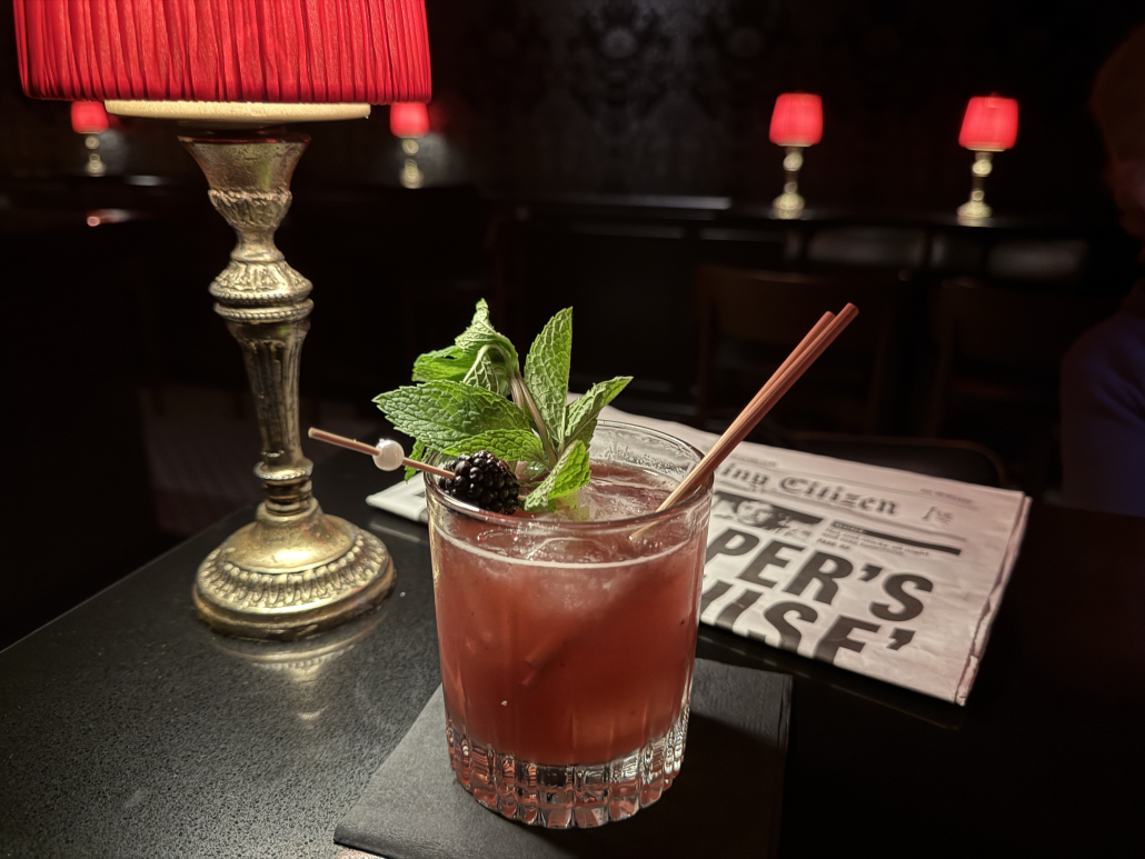The Backstabber drink on a table with a small red lamp at The Evening Citizen in Palm Springs