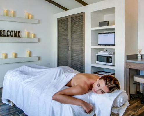 A woman covered in a towel on a white massage table
