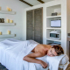 A woman covered in a towel on a white massage table