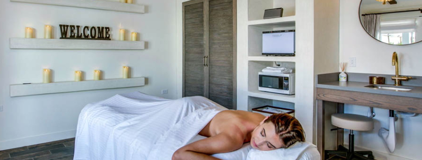 A woman covered in a towel on a white massage table