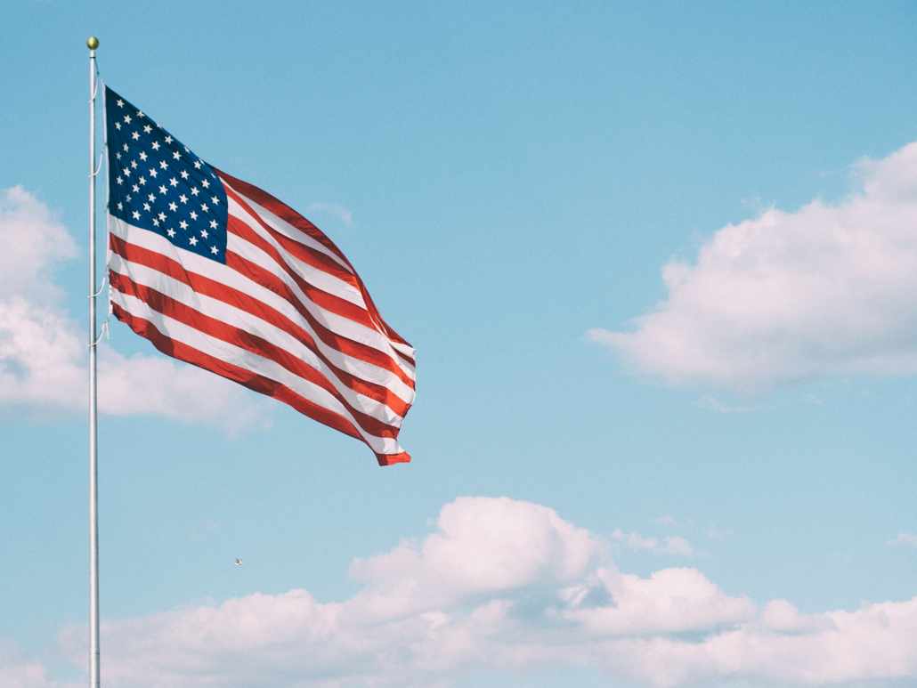 An American flag on a flag pole on a cloudy day